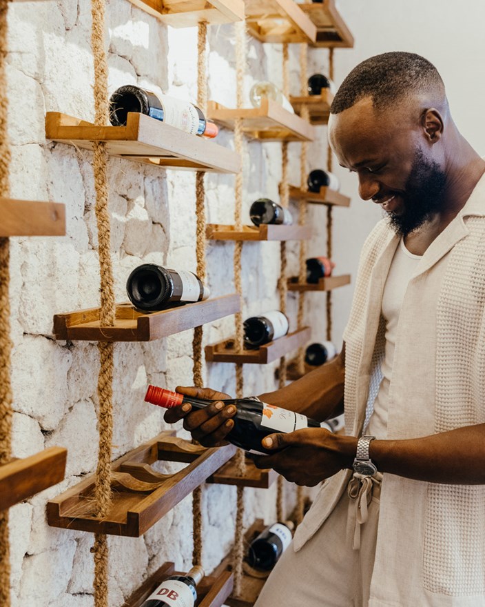 Holding a wine bottle in the Wine Cellar at LUX<bdi><bdi>*</bdi></bdi> Marijani