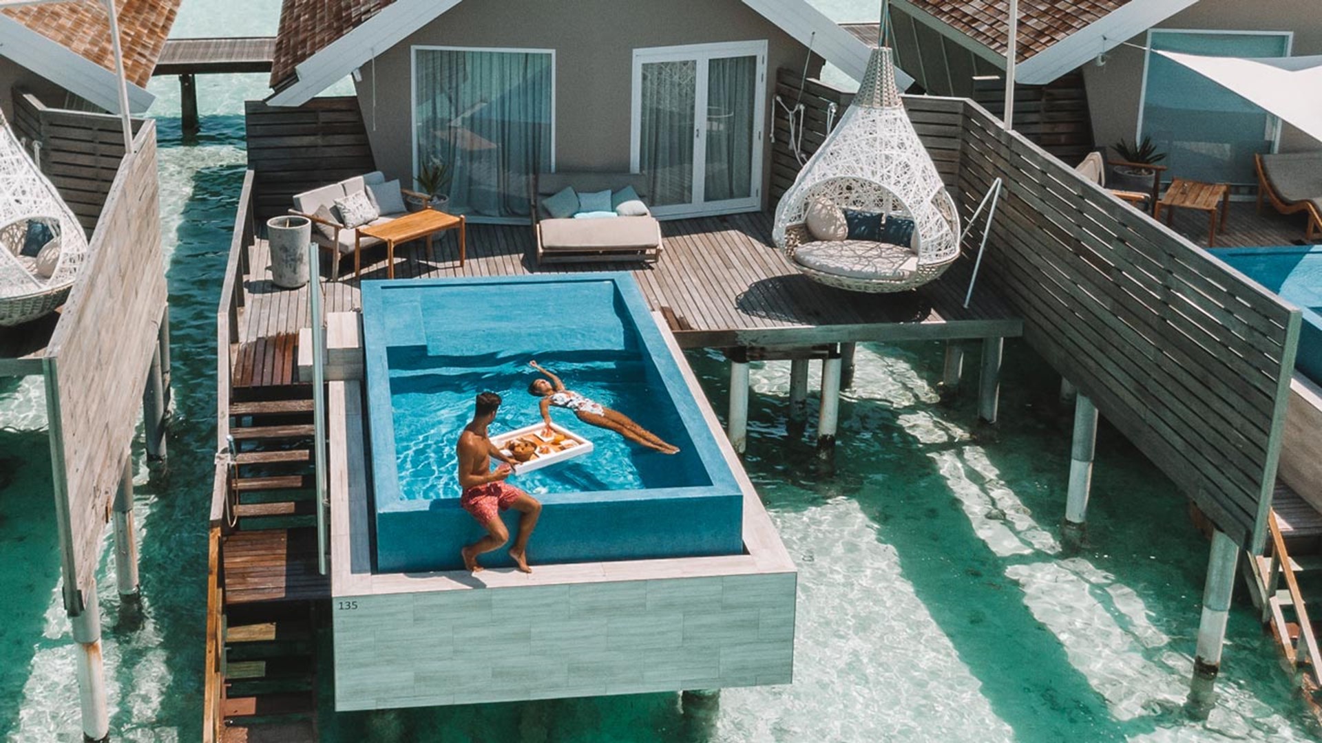 Aerial shot of couple in Temptation Pool Water Villa, LUX* South Ari Atoll